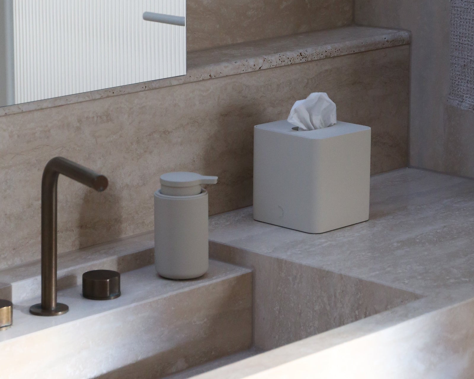Modern bathroom with a sink, faucet, and tissue box.
