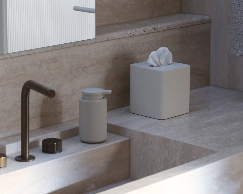 Modern bathroom with a sink, faucet, and tissue box.